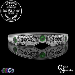 Pode incluir: Um anel de prata esterlina com um design de cardo e pedras verdes. O anel é livre de níquel e feito à mão. O anel tem um design Celtic Eternity.