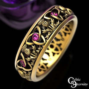 Puede incluir: Un anillo de oro con un diseño de nudo celta y tres piedras preciosas rosas. El anillo está decorado con motivos de cardo.