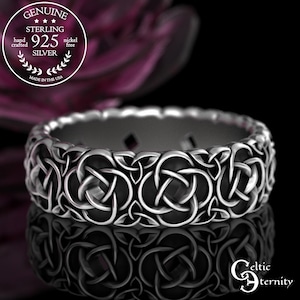 May include: A sterling silver ring with a Celtic knot design. The ring is nickel-free and hand-crafted. The ring is made in the USA. The ring has a polished finish and is reflected on a black surface.