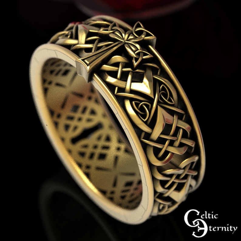 May include: A gold Celtic knot ring with a cross design. The ring is intricately detailed and features a Celtic knot pattern.