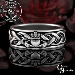May include: A sterling silver Claddagh ring with a heart, crown, and hands design. The ring features intricate Celtic knotwork and is marked "925 Silver". The ring is hand crafted and nickel free.