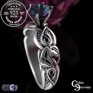 Puede incluir: Un anillo de plata de ley con una gran piedra preciosa multicolor. El anillo presenta un diseño detallado de nudo celta y caballo. El anillo está marcado con "925 SILVER" y "MADE IN THE USA".
