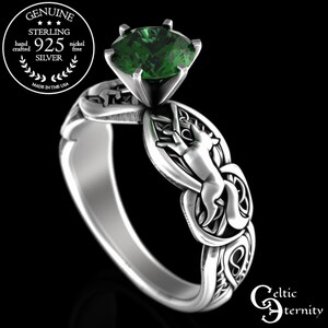 Puede incluir: Anillo de plata de ley con una piedra preciosa verde y un diseño de nudo celta con un zorro. El anillo está inscrito con "Celtic Eternity".