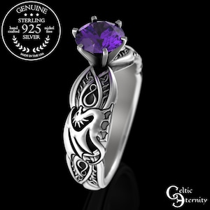 Puede incluir: Un anillo de plata de ley con una piedra preciosa púrpura y un diseño de dragón celta. El anillo está hecho en los Estados Unidos.