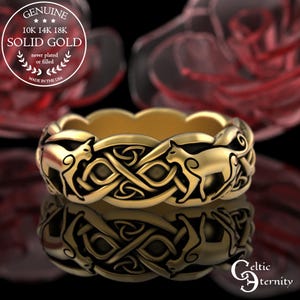 Puede incluir: Un anillo dorado con un diseño de nudo celta y figuras de animales. El anillo es de oro macizo, como indica el texto "10K 14K 18K SOLID GOLD". El anillo está hecho en los EE. UU. El anillo se refleja en la superficie inferior.