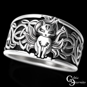 Pu&ograve; includere: Un anello d'argento con un designo a nodo celtico e un'immagine dettagliata di una volpe a nove code al centro.