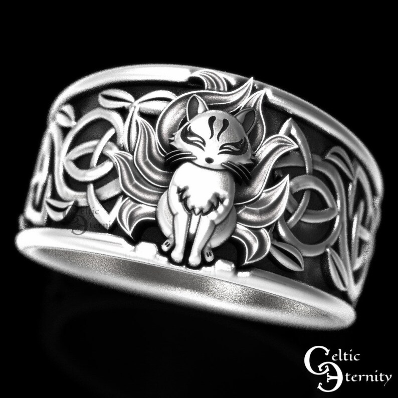 Pu&ograve; includere: Un anello d'argento con un designo a nodo celtico e un'immagine dettagliata di una volpe a nove code al centro.