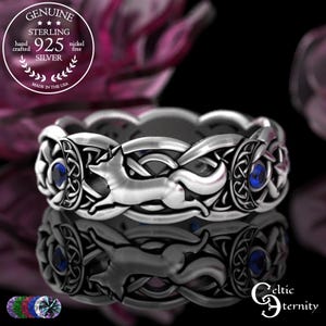 May include: A sterling silver ring with a Celtic knot design, featuring a running fox and blue gemstones. The ring is marked "925 Silver" and "Made in the USA". The ring is nickel free and hand crafted.