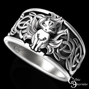 Pu&ograve; includere: Un anello d'argento con un designo a nodo celtico che presenta una rappresentazione dettagliata di una volpe a nove code, o kitsune, al centro. L'anello &egrave; un pezzo di grande impatto con dettagli intricati.