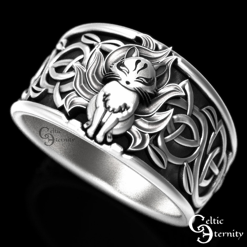 Pu&ograve; includere: Un anello d'argento con un designo a nodo celtico che presenta una rappresentazione dettagliata di una volpe a nove code, o kitsune, al centro. L'anello &egrave; un pezzo di grande impatto con dettagli intricati.