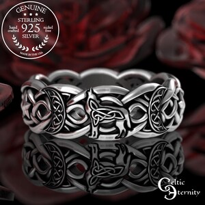 May include: A sterling silver ring with a Celtic knot design. The ring features a repeating pattern of interwoven knots and animal figures. The ring is marked "925 Silver" and "Made in the USA". The ring is nickel free.