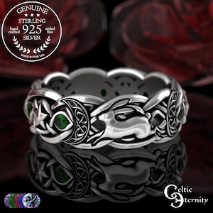 May include: A sterling silver ring with a Celtic knot design, featuring a rabbit, moon, and star motif. The ring has green gemstone accents and is marked "925 Silver". The ring is hand crafted and made in the USA.