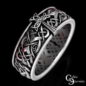 May include: Silver Celtic knot ring with a cross design. The ring is intricately detailed and features a Celtic knot pattern.