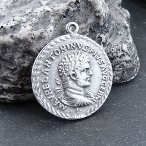 May include: Silver pendant featuring a Roman emperor bust with the inscription "IMP ANTONINVS PIVS AVG" around the edge.