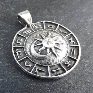May include: Silver pendant featuring a sun and moon design with the zodiac symbols around the edge.
