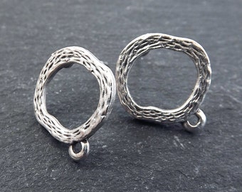May include: Two silver-toned metal rings with a textured surface and a small loop on the bottom. The rings are about 1 inch in diameter.