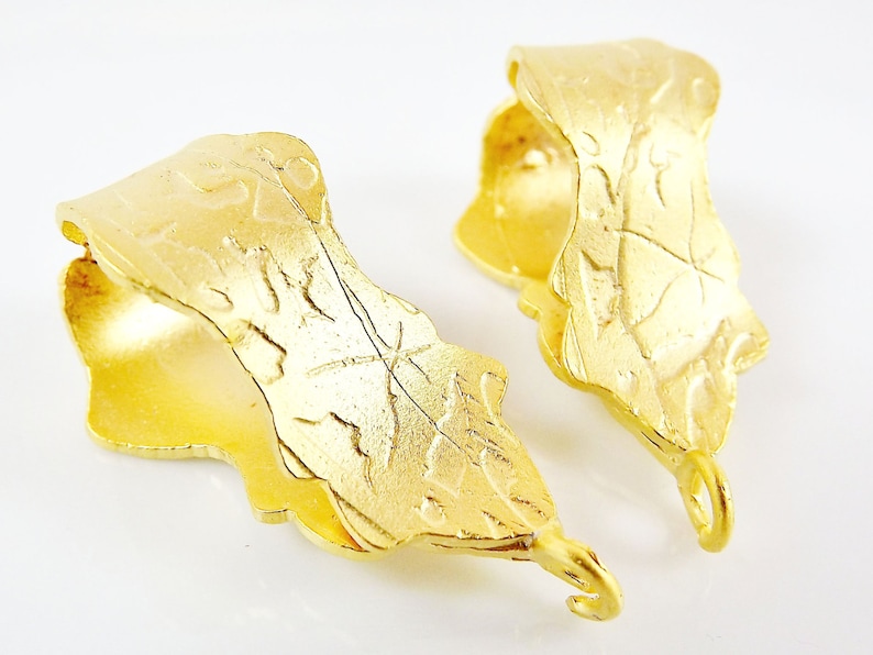 Puede incluir: Dos cierres de joyer&iacute;a de metal dorado con un dise&ntilde;o de hoja. Cada cierre tiene un bucle en el extremo.