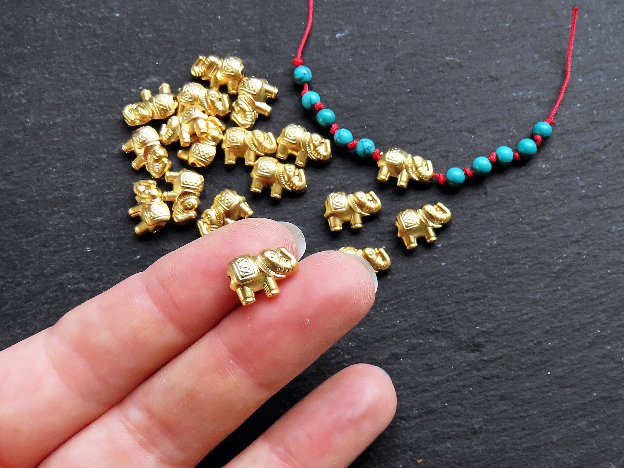 Small batch of fake jewels, beaded bag, gold metal minod…