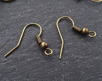 May include: Two gold-toned earring hooks with a spring and a small ball at the end.