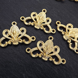 May include: Four gold-tone metal decorative connectors with a floral design. Each connector has three holes for attaching to other jewelry pieces.
