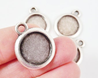 May include: Silver-toned metal pendant with a round, clear glass insert. The pendant has a loop at the top for attaching to a chain or cord.
