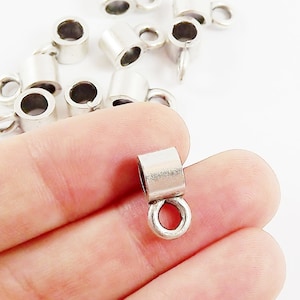 Puede incluir: Tapones de cordón de metal plateado con un pequeño bucle en el extremo. Los tapones están diseñados para ser utilizados con cordones o cadenas para crear joyas.