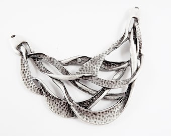 Op de afbeelding: Zilveren hanger met een getextureerd, abstract ontwerp. De hanger heeft de vorm van een halve maan en heeft een delicaat, ingewikkeld patroon.