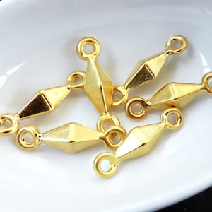 Puede incluir: Cinco abalorios de conexión de metal dorado con forma de diamante y un bucle en cada extremo.