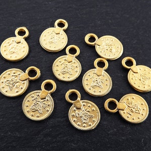 Puede incluir: Diez abalorios de metal de color dorado en forma de monedas con diseños intrincados. Cada abalorio tiene un pequeño bucle en la parte superior para sujetarlo a joyas u otras manualidades.