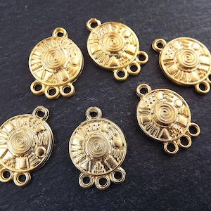 May include: Six gold-tone metal connector charms with a spiral design and three loops. Each charm has a different pattern around the spiral.