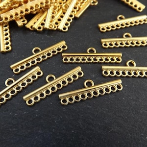 Può includere: Cappucci per perline in metallo dorato con più anelli per attaccare i gioielli. I cappucci sono lunghi circa 2,5 cm e hanno una finitura liscia e lucida.