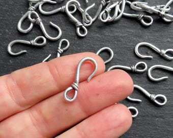 May include: Silver-toned metal hooks with a twisted wire design. The hooks are approximately 1 inch long and have a loop at the top for attaching to jewelry or other crafts.