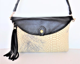 Embossed reptile or python leather crossbody bag in ivory with black trim. Convertable python leather crossbody,  wristlet or clutch.