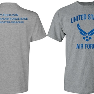 Könnte beinhalten: Ein graues T-Shirt mit dem Text "FLY-FIGHT-WIN WHITEMAN AIR FORCE BASE KNOB NOSTER-MISSOURI" auf der Rückseite und dem Text "UNITED STATES AIR FORCE" sowie dem Air Force-Logo auf der Vorderseite.