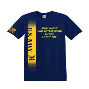 May include: A navy blue t-shirt with a yellow vertical stripe down the left side. The stripe features the words "U.S. NAVY" in yellow letters, a small eagle graphic, and the text "SEMPER FORTIS" NAVAL SUPPORT ACTIVITY BAHRAIN U.S. FIFTH FLEET in yellow letters.