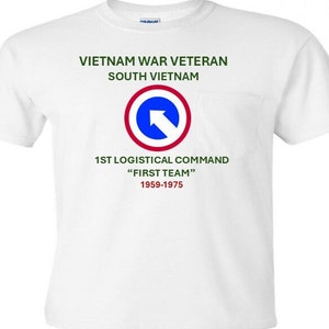 Może przedstawiać: Biała koszulka z zieloną kieszenią, na której znajduje się niebieskie i czerwone koło z białą strzałką skierowaną w prawo. Tekst "Vietnam War Veteran South Vietnam 1st Logistical Command "First Team" 1959-1975" jest nadrukowany na zielono.