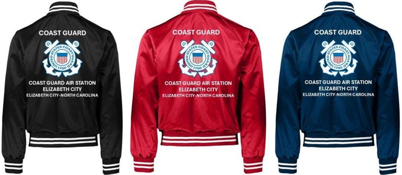 Puede incluir: Tres chaquetas bomber de sat&eacute;n en negro, rojo y azul marino. Cada chaqueta presenta pu&ntilde;os y cuello a rayas blancas, y el texto "COAST GUARD" encima de un emblema de la Guardia Costera y el texto "COAST GUARD AIR STATION ELIZABETH CITY NORTH CAROLINA".