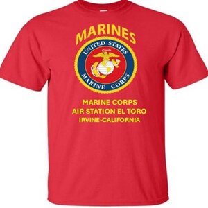 May include: Red t-shirt featuring the US Marine Corps emblem in a circular design with the words "Marines", "United States", and "Marine Corps". Below the emblem are the words "Marine Corps Air Station El Toro, Irvine-California".