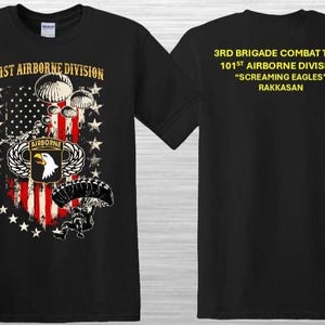 May include: Black t-shirt featuring a patriotic design with an American flag motif, parachutes, and an eagle emblem. The front of the shirt displays "101st Airborne Division". The back of the shirt displays "3rd Brigade Combat Team".