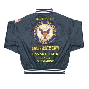 May include: A dark blue bomber jacket with a white and black striped collar and cuffs. The back of the jacket features an embroidered United States Navy seal with the words "SEMPER FORTIS", "UNITED STATES NAVY", "WORLD'S GREATEST NAVY", "USS SKIPJACK", "SSN-585", and "SUBMARINE".