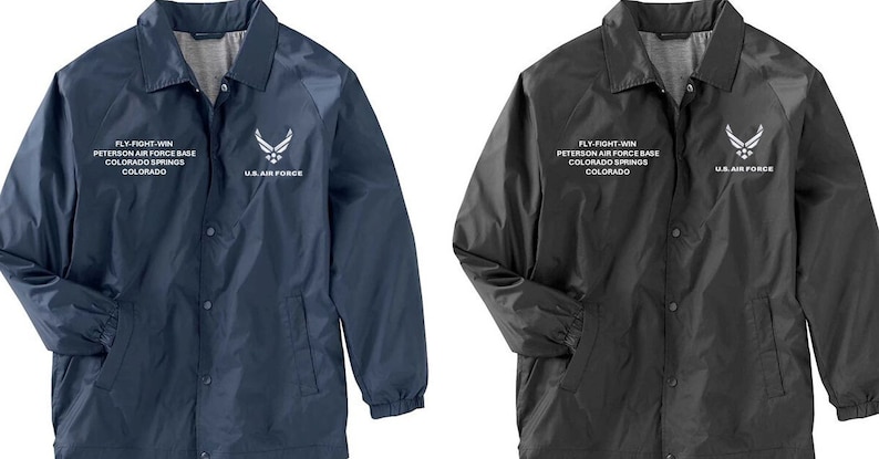 May include: Two baseball jackets, one navy blue and one black, with the text "FLY FIGHT WIN" and "PETERSON AIR FORCE BASE" and "COLORADO SPRINGS" and "COLORADO" and "U.S. AIR FORCE" embroidered on the front.