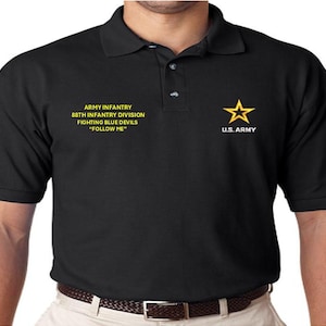 Op de afbeelding: Zwart poloshirt met een geborduurde US Army-ster in geel en tekst die luidt "Army Infantry 88th Infantry Division Fighting Blue Devils "Follow Me""
