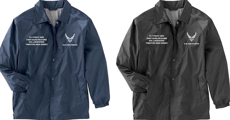 May include: Two navy blue and black jackets with a white embroidered U.S. Air Force logo and text that reads "Fly-Fight-Win Joint Base McGuire Dix-Lakehurst Trenton New Jersey".