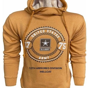 May include: Mustard-colored hoodie with a drawstring hood and a large graphic on the front. The graphic features the words "UNITED STATES ARMY" around a star and the text "12TH ARMORED DIVISION HELLCAT". The hoodie has a zipper pocket on the side.