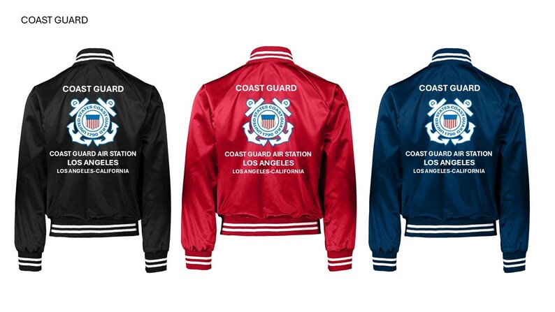 May include: Three satin bomber jackets in black, red, and navy blue. Each jacket features the words "Coast Guard" above a crest and text that reads "Coast Guard Air Station Los Angeles Los Angeles-California". The jackets have white and black striped cuffs and collars.