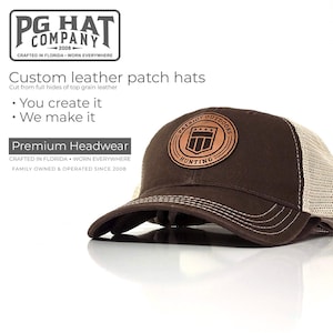 May include: A brown trucker hat with a tan mesh back and a leather patch. The patch features the text "PATRIOT OUTDOORS HUNTING" around a shield design. The hat is from PG Hat Company.