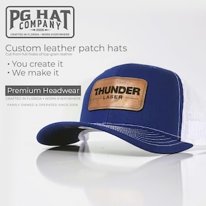 May include: A blue trucker hat with a white mesh back and a curved brim. The hat features a brown leather patch with the text "THUNDER LASER". The hat is from PG Hat Company.