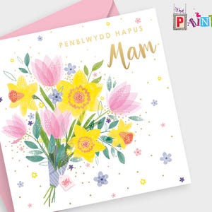 May include: A white card with a pink envelope. The card features a bouquet of pink tulips and yellow daffodils with green leaves. The text "PENBLWYDD HAPUS Mam" is written in gold lettering on the card.