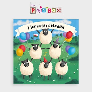 May include: A birthday card featuring a group of six sheep wearing party hats and holding balloons. The card has a banner that says "Llongyfarchiadau" which is Welsh for "Congratulations".