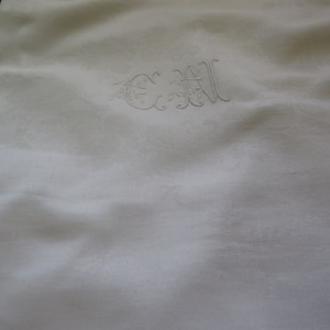 Peut inclure: Nappe en lin blanc avec un monogramme brodé délicat des lettres "C.W." dans une police d'écriture cursive.